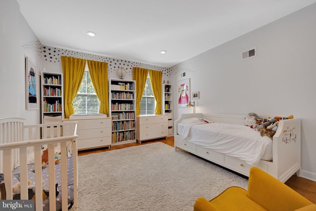 bedroom with recessed lighting, wood finished floors, and visible vents