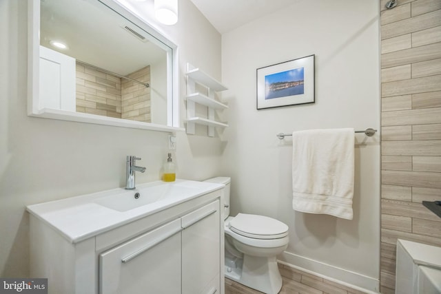 full bathroom with vanity, toilet, baseboards, wood finished floors, and visible vents