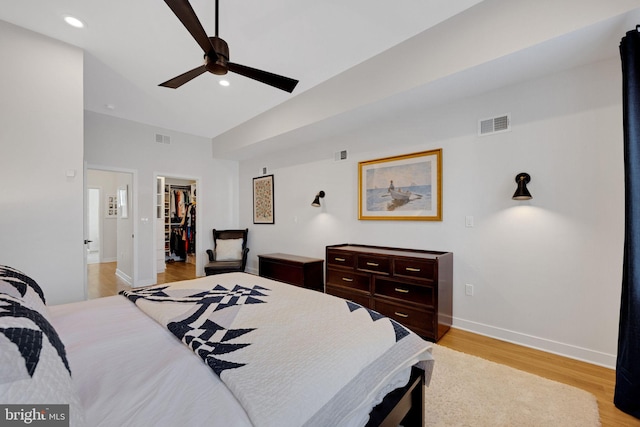 bedroom with light wood-type flooring, baseboards, a spacious closet, and visible vents