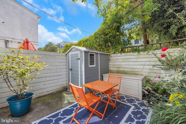 view of shed with a fenced backyard and outdoor dining space