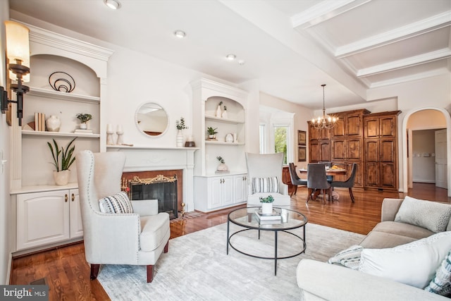 10601 Little Run Farm Ct, Vienna, VA 22182 - living area with arched walkways, a fireplace, built in shelves, wood finished floors, and an inviting chandelier