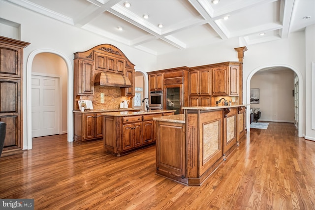 10601 Little Run Farm Ct, Vienna, VA 22182 - kitchen featuring stainless steel oven, arched walkways, a center island with sink, built in fridge, and coffered ceiling