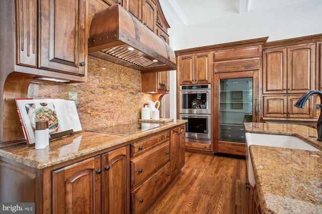 10601 Little Run Farm Ct, Vienna, VA 22182 - kitchen with stainless steel double oven, black electric stovetop, a sink, premium range hood, and wood finished floors