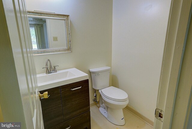 bathroom featuring toilet, vanity, baseboards, and tile patterned floors