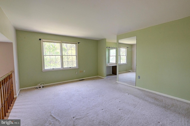 carpeted spare room featuring baseboards