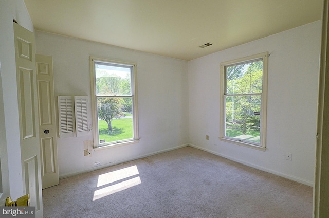 unfurnished room featuring plenty of natural light, carpet flooring, and baseboards