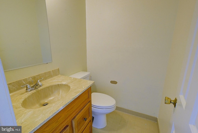 half bathroom with toilet, vanity, and baseboards