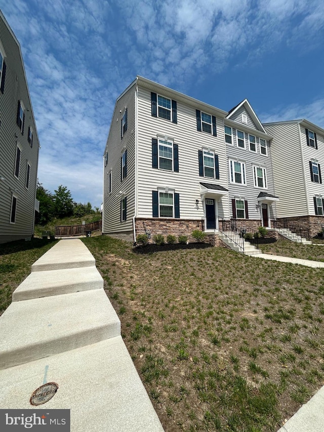 view of front of home with a front lawn and stone siding