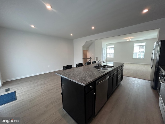 1108 Dovetail Cir, Fredericksburg, VA 22401 - kitchen featuring open floor plan, stainless steel appliances, dark cabinetry, dark stone counters, and a kitchen island with sink