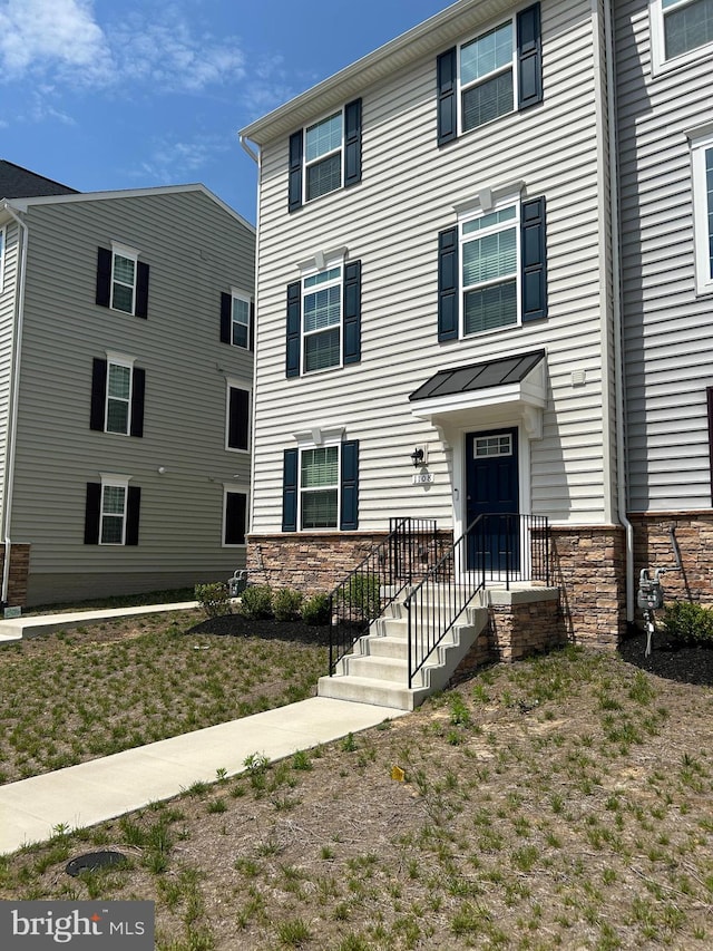 townhome / multi-family property featuring stone siding