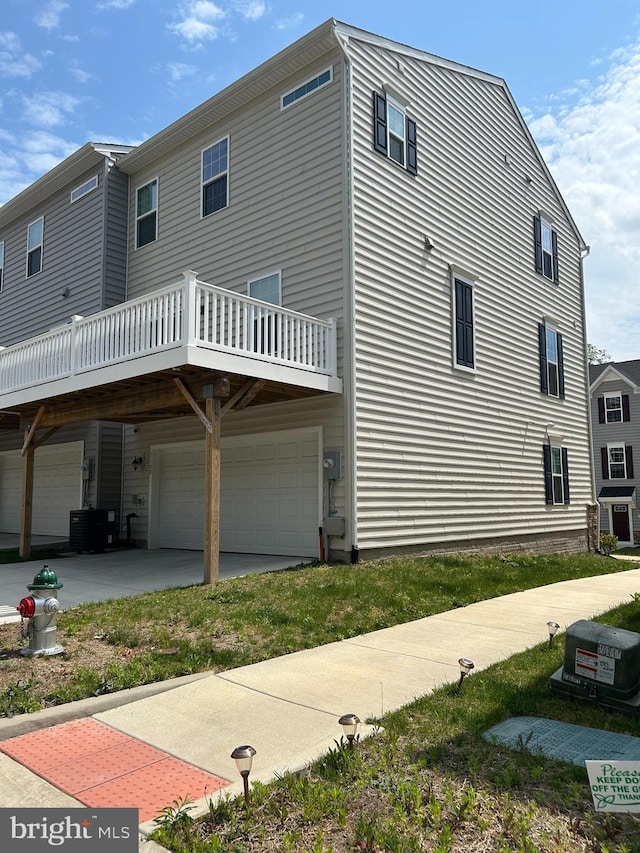 exterior space with an attached garage and central AC unit