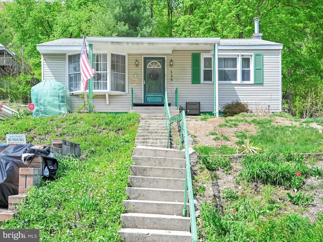 view of front of home featuring covered porch and stairs