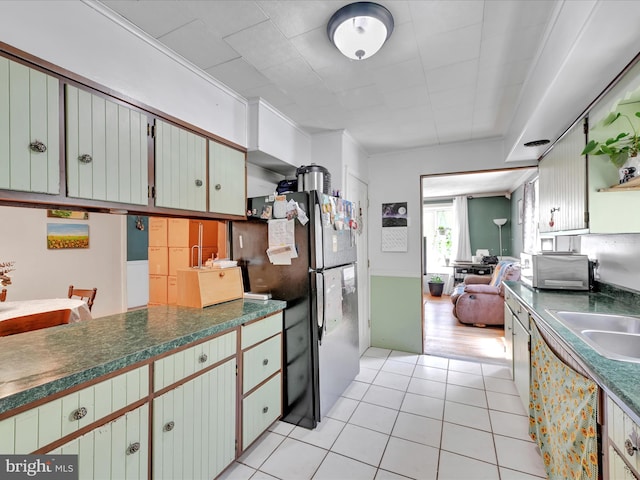kitchen with freestanding refrigerator, light tile patterned floors, and dark countertops