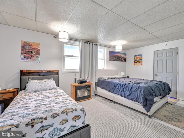 carpeted bedroom featuring a paneled ceiling