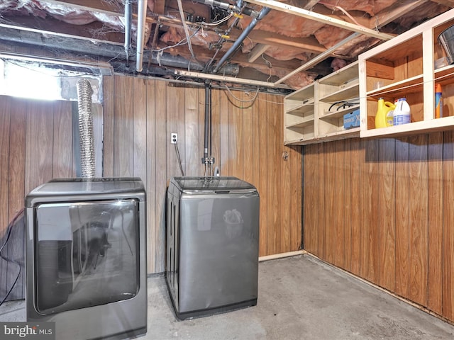 unfinished below grade area featuring washing machine and dryer and wooden walls