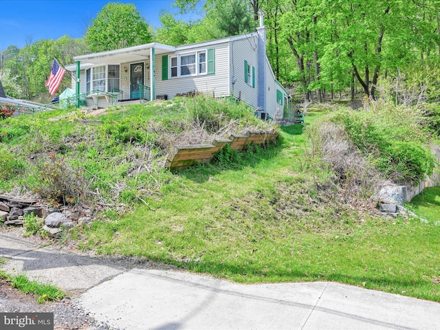 view of front of home featuring covered porch and a front lawn