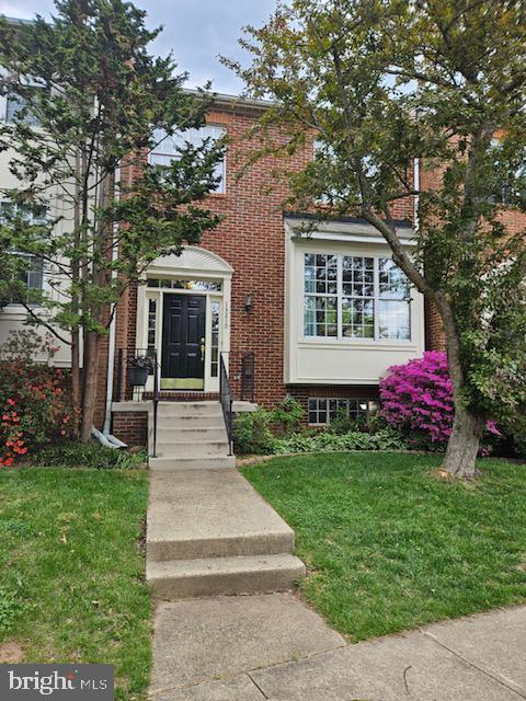 view of front of property featuring brick siding and a front lawn