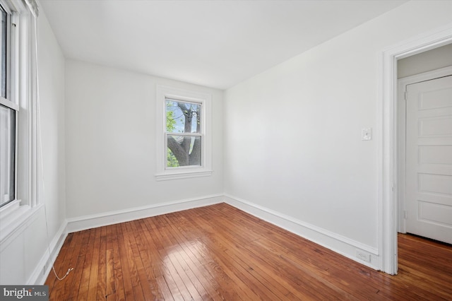 unfurnished room with baseboards and hardwood / wood-style floors