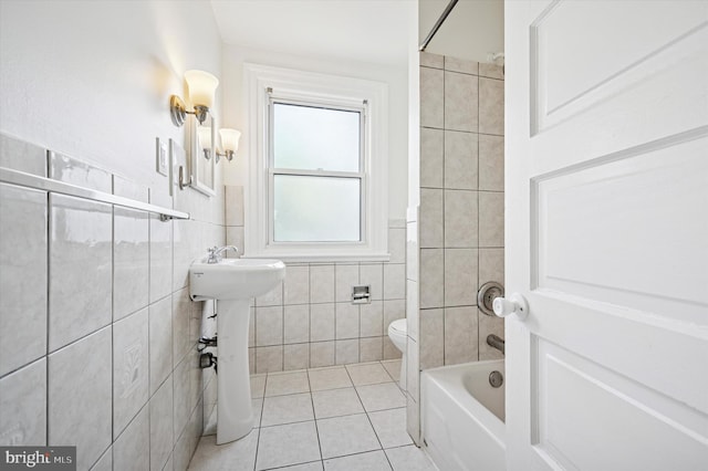 full bathroom featuring toilet, a wainscoted wall, shower / washtub combination, tile patterned floors, and tile walls