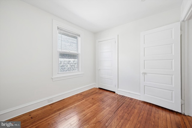 unfurnished bedroom featuring baseboards and hardwood / wood-style flooring