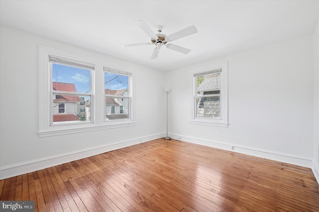 unfurnished room with baseboards, ceiling fan, and wood-type flooring