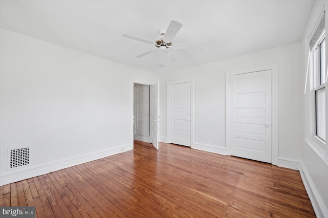 unfurnished bedroom with ceiling fan, baseboards, light wood-type flooring, and visible vents