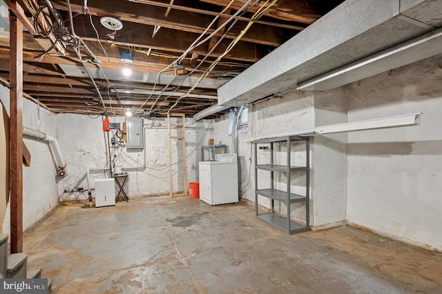 unfinished basement with electric panel and washer / dryer