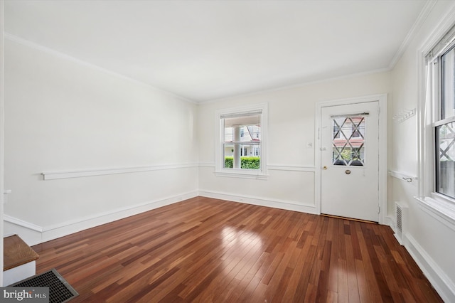 interior space featuring crown molding, visible vents, baseboards, and hardwood / wood-style flooring