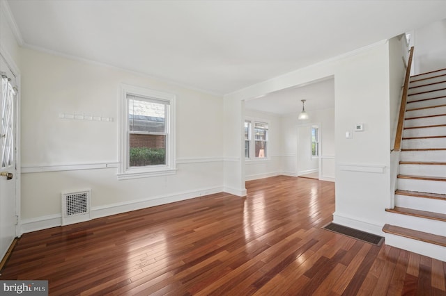 interior space with a wealth of natural light, visible vents, hardwood / wood-style floors, and stairs