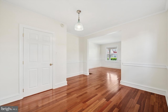 interior space with crown molding, baseboards, and wood finished floors