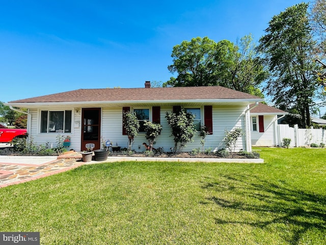 ranch-style home with a chimney, fence, and a front yard