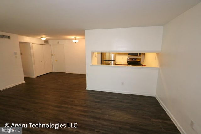 unfurnished living room with baseboards, dark wood-style flooring, and visible vents