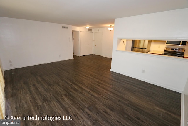 unfurnished living room with dark wood-style flooring, baseboards, and visible vents