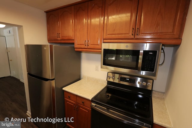 kitchen with brown cabinetry, light countertops, and stainless steel appliances