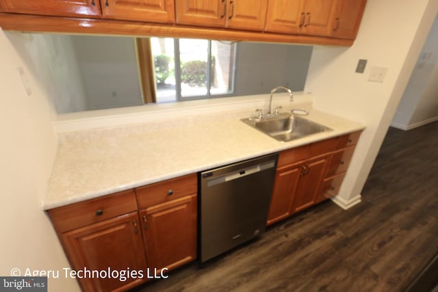 kitchen with stainless steel dishwasher, a sink, dark wood-style flooring, and light countertops