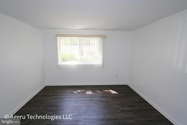 unfurnished room featuring baseboards and wood finished floors