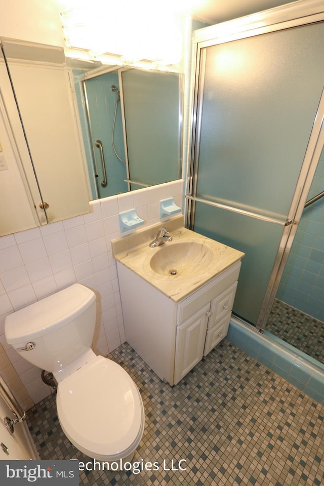 bathroom with vanity, tile patterned floors, a stall shower, and toilet