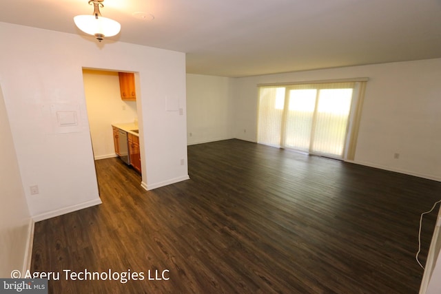 empty room featuring dark wood-style flooring and baseboards