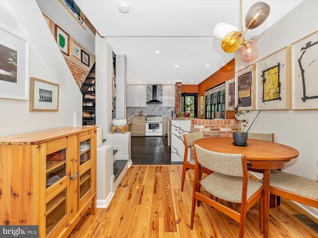 dining area with light wood finished floors and recessed lighting