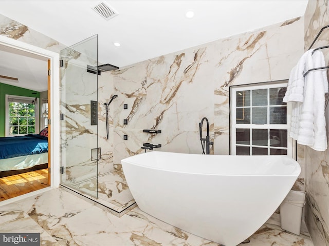 bathroom featuring ensuite bath, stone wall, marble tiled flooring, recessed lighting, and tile walls