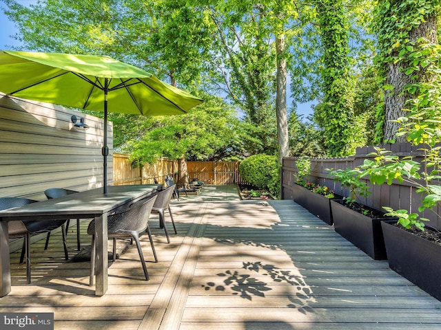 deck with outdoor dining area and a fenced backyard