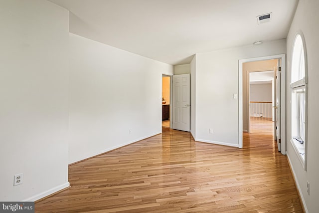 unfurnished bedroom featuring baseboards, visible vents, and light wood-style floors