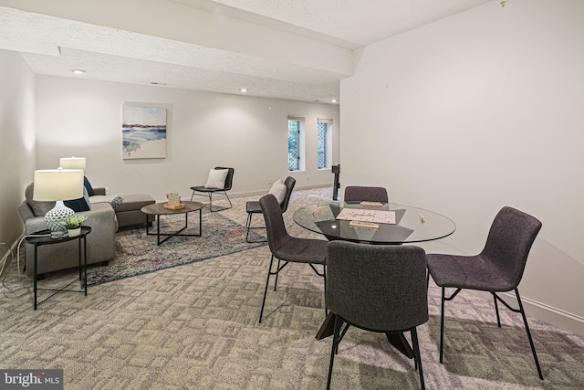 dining room with baseboards, carpet, and a textured ceiling