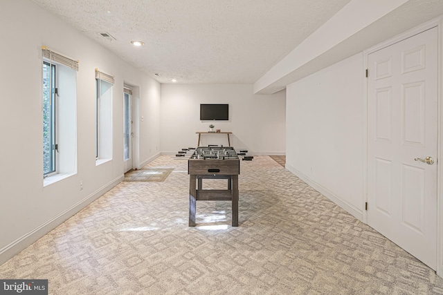 playroom with a healthy amount of sunlight, carpet floors, a textured ceiling, and visible vents
