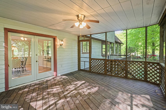 unfurnished sunroom with a ceiling fan and french doors