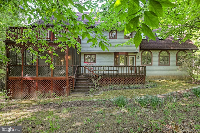 rear view of house featuring roof with shingles and a deck