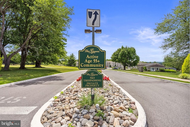 community sign featuring a yard