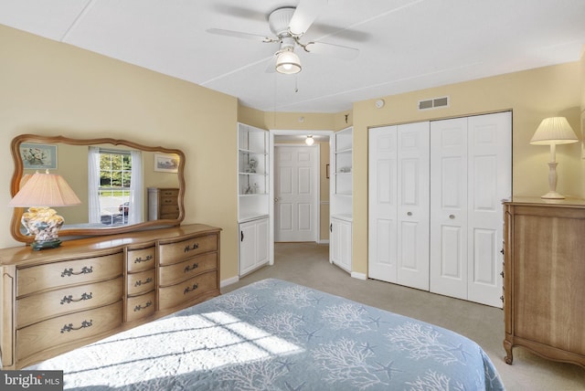 bedroom featuring a ceiling fan, visible vents, light carpet, and a closet