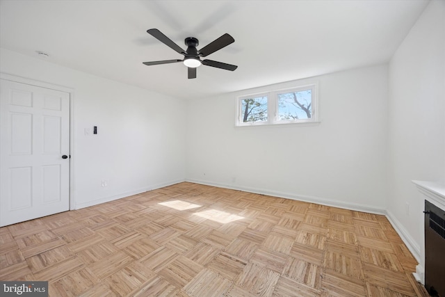 empty room featuring baseboards, a ceiling fan, and radiator heating unit