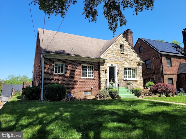 view of front facade with a front lawn, stone siding, and a chimney